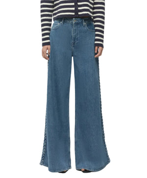 Person wearing Simkhai Booker Straight Jean in blue, styled with lace-up side details, paired with a black-and-white striped long-sleeve top.