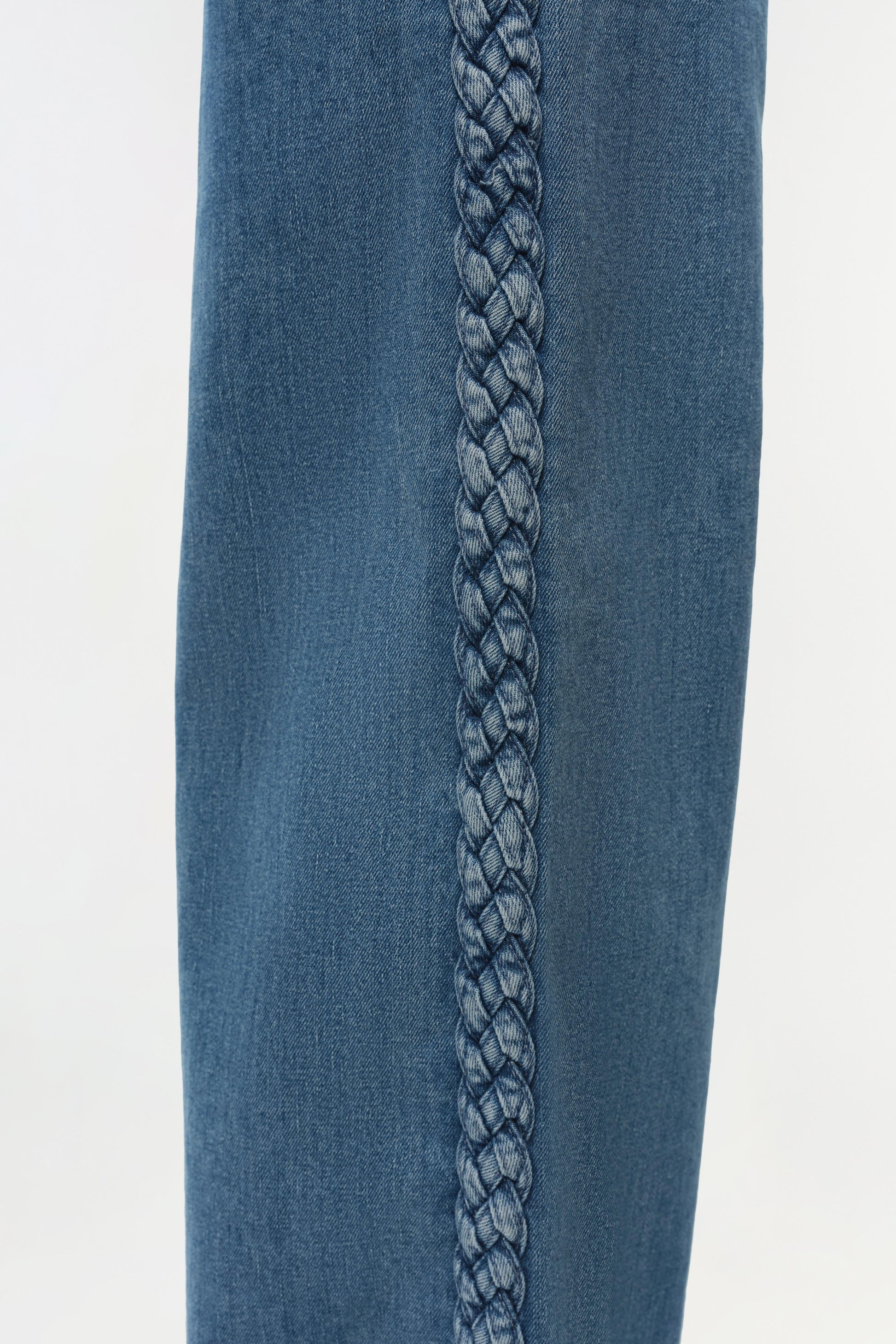 Close-up of premium denim fabric with a braided detail down the center, highlighting the quality craftsmanship of Simkhai’s Booker Straight Jean, inspired by classic 5-pocket styles.