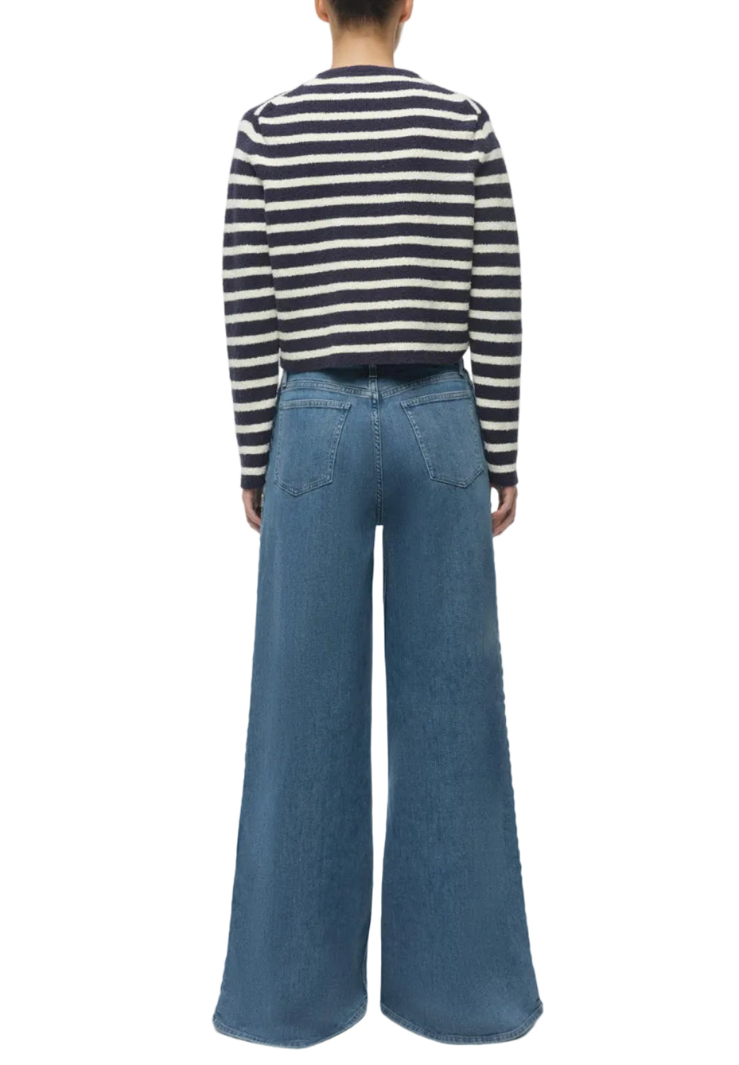 Person stands with back to camera, wearing a black and white striped long-sleeve shirt and Simkhai Booker Straight Jean—premium high-waisted blue denim with classic 5-pocket style.