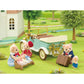 Four Calico Critters bear figures and two bear cubs gather around the Classic Family Car, which comes with suitcases, a pram, and charming accessories, outside a white house in a grassy outdoor setting.