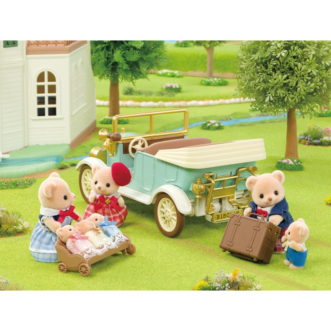 Four Calico Critters bear figures and two bear cubs gather around the Classic Family Car, which comes with suitcases, a pram, and charming accessories, outside a white house in a grassy outdoor setting.