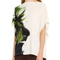 A woman wearing the Jason Wu Collection Asymmetrical Printed Crepe Boatneck Top, featuring green and black brushstroke patterns, elegantly paired with brown pants.