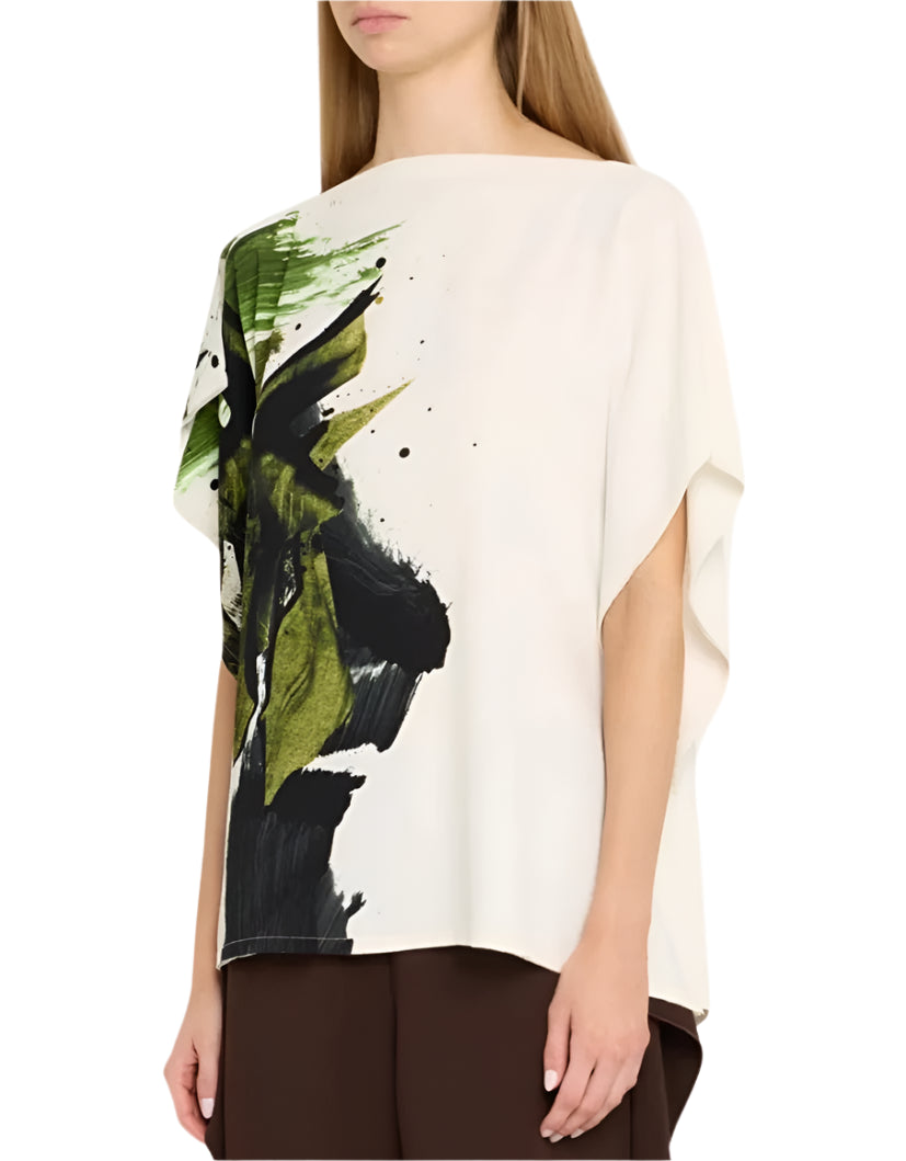 A woman wearing the Jason Wu Collection Asymmetrical Printed Crepe Boatneck Top, featuring green and black brushstroke patterns, elegantly paired with brown pants.