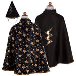 The Great Pretenders Reversible Wizard Cape & Hat set for children includes a black wizard cape decorated with gold stars, a reversible cape featuring a gold lightning bolt, and a black pointed wizard hat accented with a gold lightning bolt.