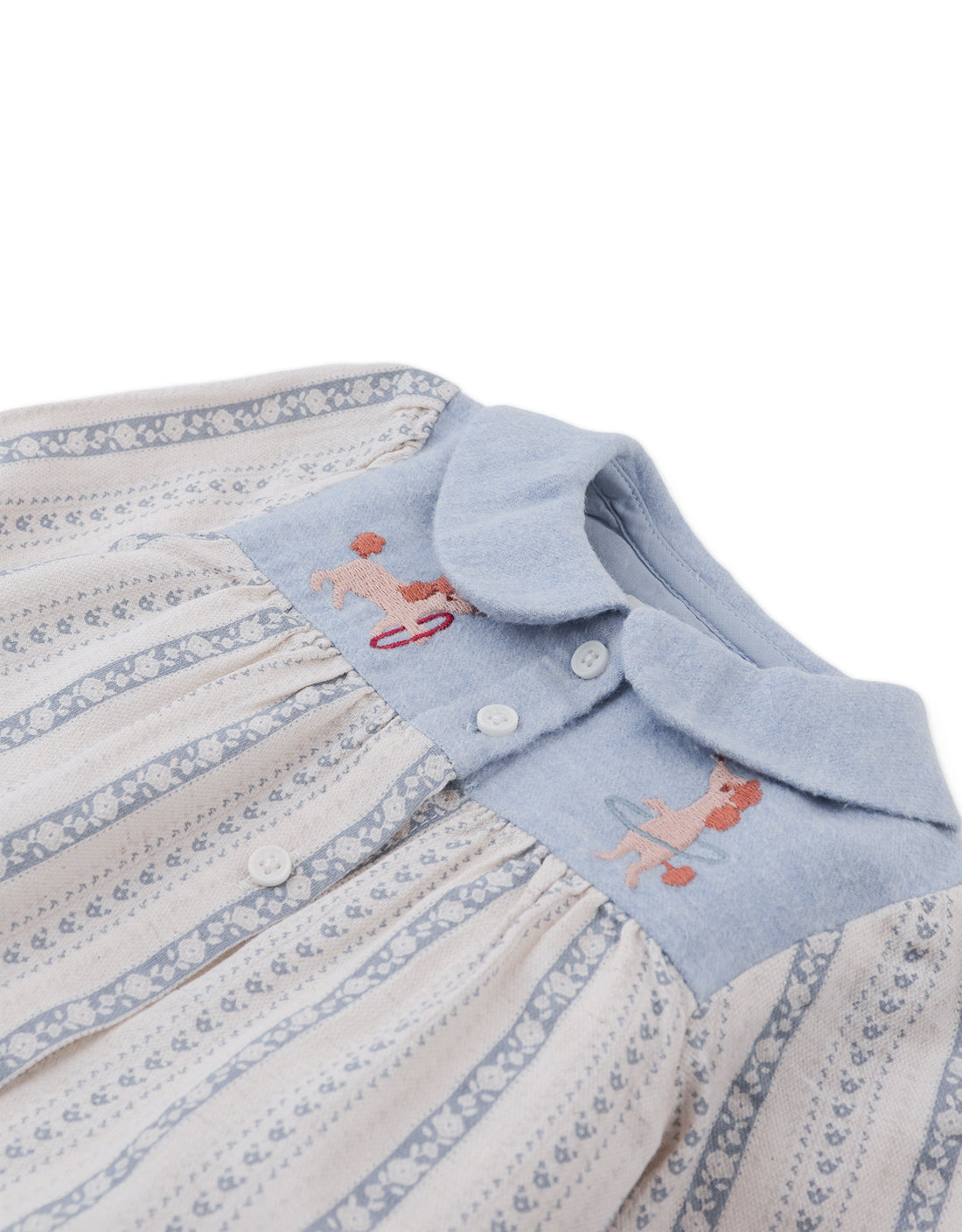 Close-up of the Gingersnaps Baby Girls’ Hester Striped Floral Blouse, a light blue and cream striped top with a Peter Pan collar and delicate embroidered poodles near the neckline.