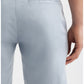 A person is shown from the back waist to above the knee wearing AG Jeans' Wanderer Shorts Linen in a light blue shade, featuring a slim cut, belt loops, and back welt pockets. One hand rests by their side, highlighting these warm weather shorts.