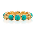 The Berry Gem Ring by Juliska Capucine De Wulf is a gold band adorned with evenly spaced round turquoise stones featuring black veining, accented by delicate gold floral details between each stone.