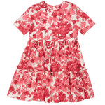 The Cara Cara Girls' Margaux Dress features short sleeves, a red and white berries floral print, a fitted bodice, and an A-line silhouette with a tiered, gathered skirt.