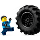 A LEGO® City Blue Monster Truck minifigure in blue runs from a large rolling tire, inspired by Legos - Toyhouse, on a white background.