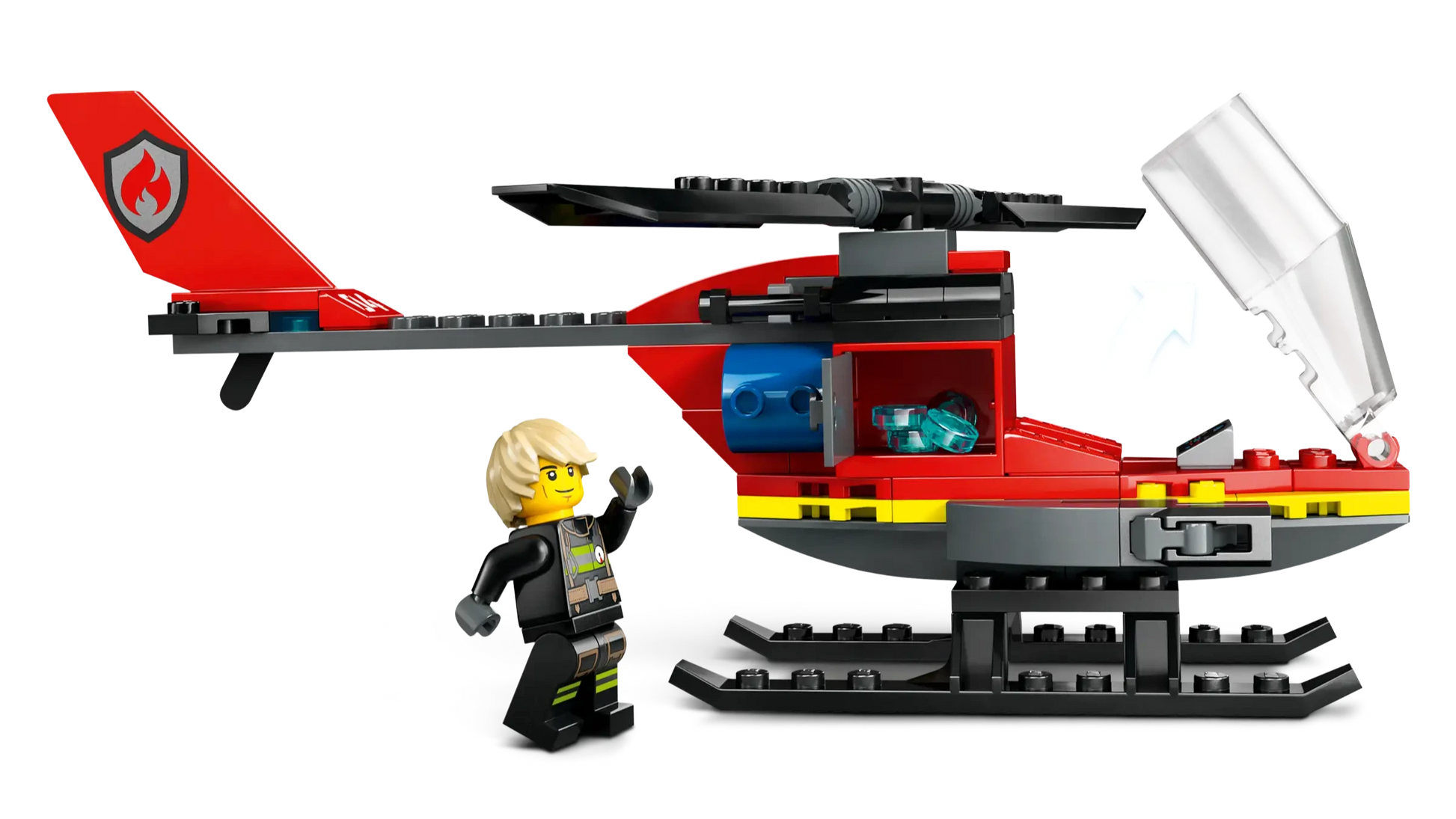 A LEGO minifigure stands beside the LEGO® City Fire Rescue Helicopter by Legos - Toyhouse, a red and black set with an open cockpit canopy and fire emblem on its tail.