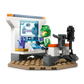 A LEGO astronaut in a green spacesuit engages with a high-tech screen amid a control panel and space decor. This is from the Space Crew Minifigures set, inspired by the thrilling LEGO® City Spaceship and Asteroid Discovery mission by Legos - Toyhouse.