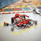 A LEGO® City F1® Pit Stop & Pit Crew with Ferrari Car by Legos - Toyhouse is set up on the floor, featuring minifigures working on a red Ferrari Formula 1 car with accessories scattered around.