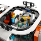 Two LEGO astronaut minifigures are in the white and orange cockpit of the LEGO® City Modular Galactic Spaceship by Legos - Toyhouse, with one sitting and the other reclining in a control chair.