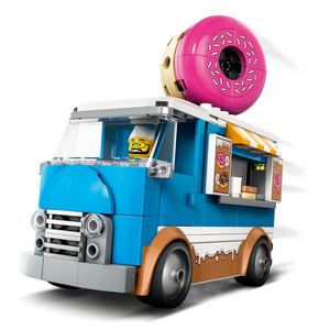 The LEGO® City Donut Truck by Legos - Toyhouse features a blue and white design, a giant pink donut on top, serving window, and a minifigure driver—ideal for fans of the LEGO donut shop theme.