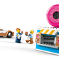 Embark on tasty adventures with the LEGO® City Donut Truck from Legos - Toyhouse, featuring a blue truck, two minifigures, and a vibrant donut shop topped with a giant pink donut sign!.