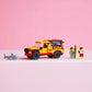 A yellow and red LEGO® City Lifeguard Beach Rescue Truck by Legos - Toyhouse, two toy figures with a surfboard, and a toy shark are arranged in a row against a pink background.