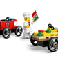 Three LEGO minifigures join the LEGO® City Pizza vs. Fire Truck Race Car Pack by Legos - Toyhouse: a firefighter with a red cart, a chef with a pizza sign, and a yellow race car featuring pizza-themed decorations and red flags.