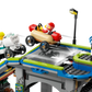 Two toy figures race small cars on the LEGO® City No Limits: Race Car Ramp Track by Legos - Toyhouse, with ramps, a streetlight, and traffic signs—perfect for thrilling soapbox racing adventures.
