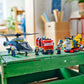 Three vehicles from the Legos - Toyhouse LEGO® City Helicopter, Fire Truck & Submarine Remix set are shown on a green wooden crate, surrounded by several LEGO minifigures.