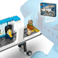 Three LEGO® minifigures walk through an airport jet bridge toward a toy airplane, with the Legos - Toyhouse LEGO® City Airport with Airplane box visible in the background.