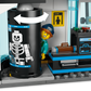 A minifigure from the LEGO® City Airport with Airplane by Legos - Toyhouse enters a security scanner, showing a skeleton X-ray, with the kit’s conveyor belt and luggage visible nearby.