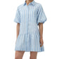 A woman wears the Simkhai Crissy Stripe Dress, a light blue and white satin mini shirtdress featuring puffed short sleeves and a collar.