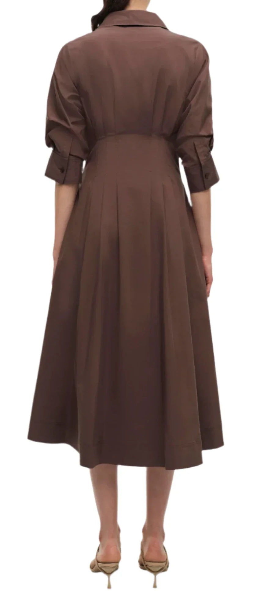 A woman wearing a Simkhai Signature Jazz Dress in brown, made entirely from cotton and featuring a tailored bodice, stands with her back to the camera.