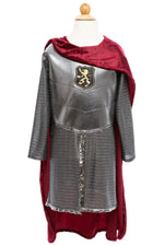 Great Pretenders Silver Knight with Cape, 5-6Y—a child’s medieval knight costume featuring a silver chainmail-patterned tunic, metallic chest plate with lion crest, and burgundy velvet cape—displayed on a mannequin.