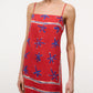 A person wearing the Laura Linen Maxi Dress by Staud, featuring adjustable spaghetti straps and a blue and white abstract star pattern.