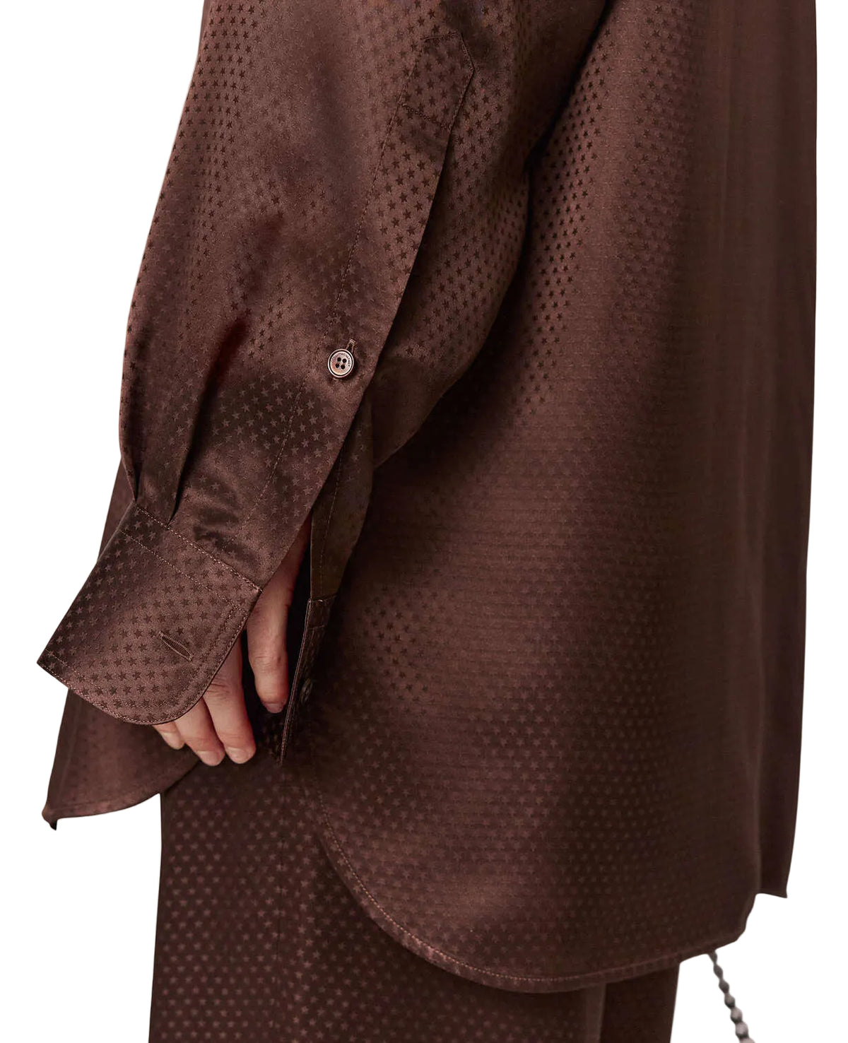 Close-up of a person wearing a brown long-sleeved Stella McCartney Star Silk Jacquard Shirt with a subtle star-patterned jacquard.