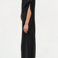 A person in profile models the Simkhai Sadia Cape Mini Dress—loose-fitting and black with short sleeves—paired with black pointed-toe boots, showcasing modern glamour against a plain white background.