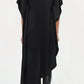 Shown from the back, a person wears the Simkhai Sadia Cape Mini Dress—black, knee-length with an asymmetric hemline and short sleeves—paired with black boots for an effortlessly modern look.