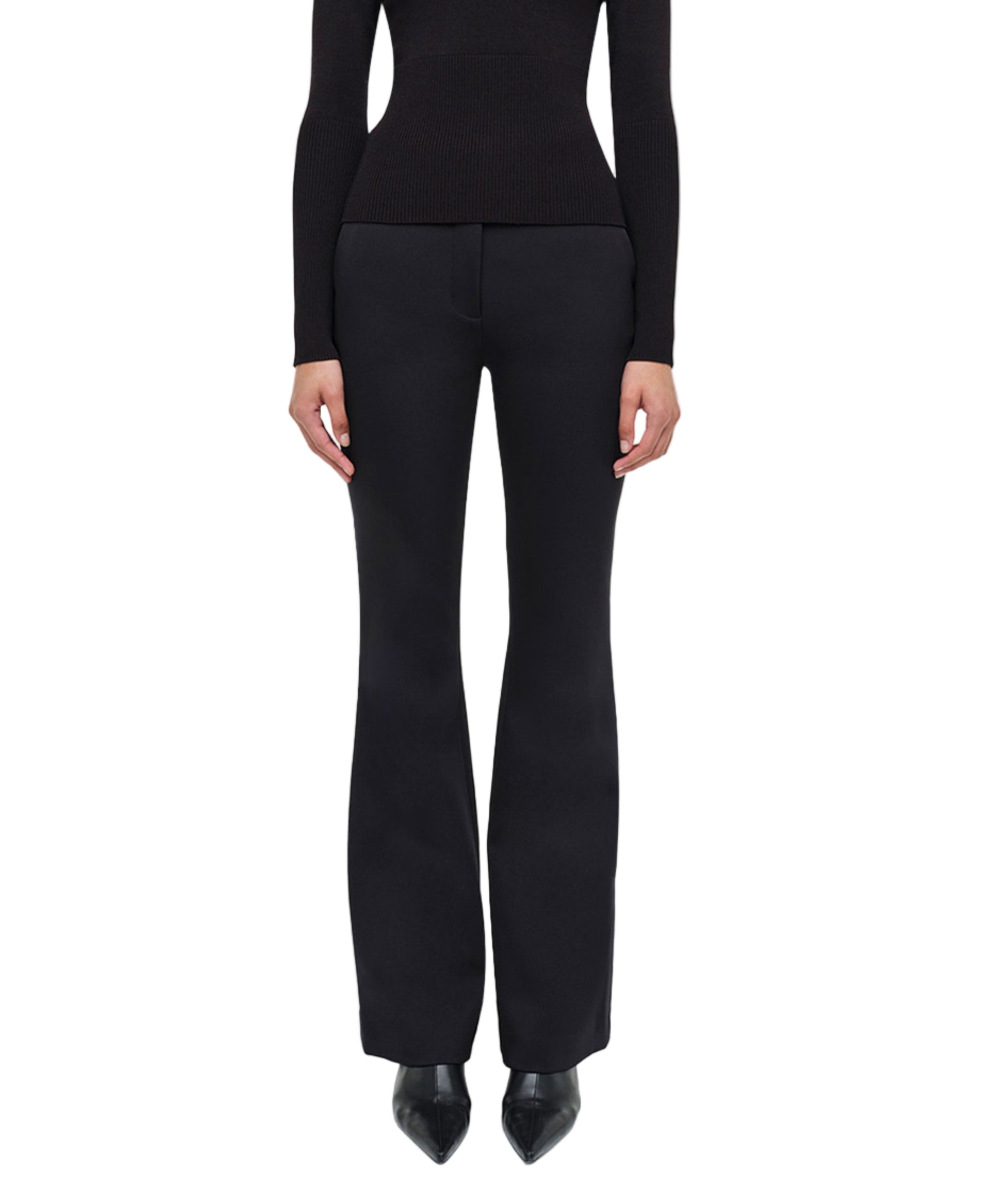 A person stands facing forward against a white background, embodying refined minimalism in the Simkhai Kenna Trouser paired with a fitted black long-sleeve top.