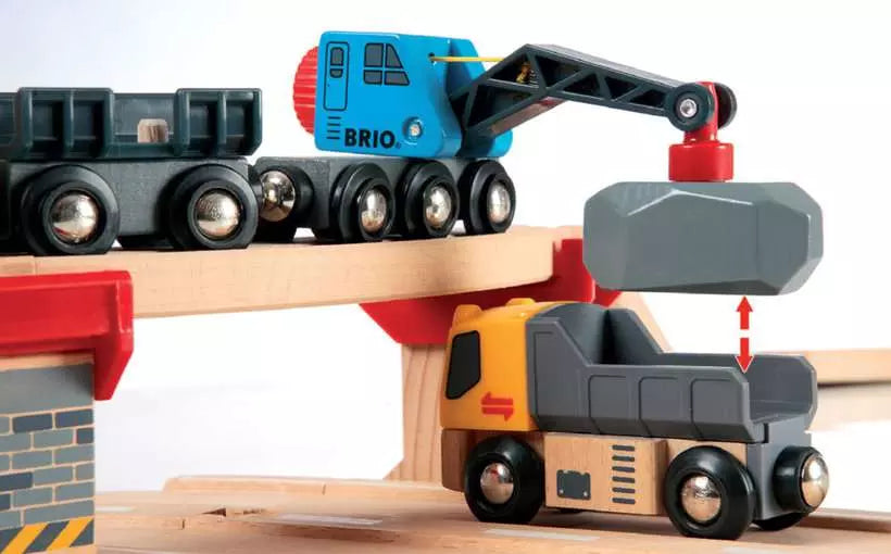 A wooden toy construction train set featuring a crane and truck by Brio World. 