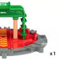 The BRIO World Turntable & Figure by Brio comes with a toy rotating railway turntable featuring green and red parts, along with a toy figure dressed in blue overalls and a blue cap. It is perfect for enhancing your BRIO World railway set with seamless track connection points.