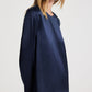 A person wearing a long-sleeved, navy blue, round-neck TWP Nightfall Dress.