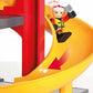 A Brio World toy fireman is riding down a yellow slide.