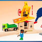 Experience endless railway fun with the BRIO World Action Tunnel Deluxe Set from Brio, featuring a toy construction set complete with a crane, green truck, figure, and road sign on a wooden track. A hand illustrates the crane's operating mechanism. Integrate it seamlessly with Action Tunnel and Smart Tech Sound for an immersive play adventure.