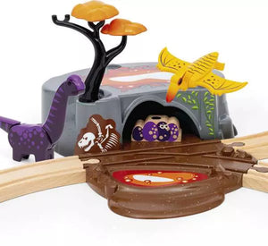 The BRIO Dinosaur Adventure Set by Brio includes a toy dinosaur playset featuring a purple dinosaur, yellow flying dino, tree, cave, wooden tracks for thrilling dinosaur-themed play, and a fossil illustration.