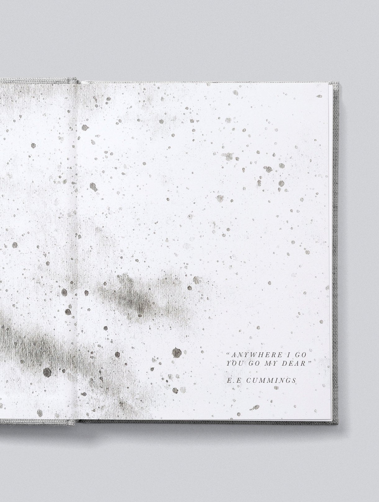 An open Write to Me Bump A Pregnancy Story, Oatmeal journal reveals a page with gray speckles, featuring the quote: "Anywhere I go you go, my dear" by E.E. Cummings. It's an ideal choice for your weekly journal update or as a heartfelt addition to your pregnancy journal.