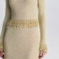 Simkhai Tali Pearl Fringe Top in a gold long-sleeved metallic bouclé design featuring a fringe waist and cuffs accented with dangling pearls.