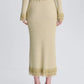Back view of the Simkhai Zeni Midi Skirt in gold metallic bouclé, featuring pearl-adorned fringe trim at the waist and hem.