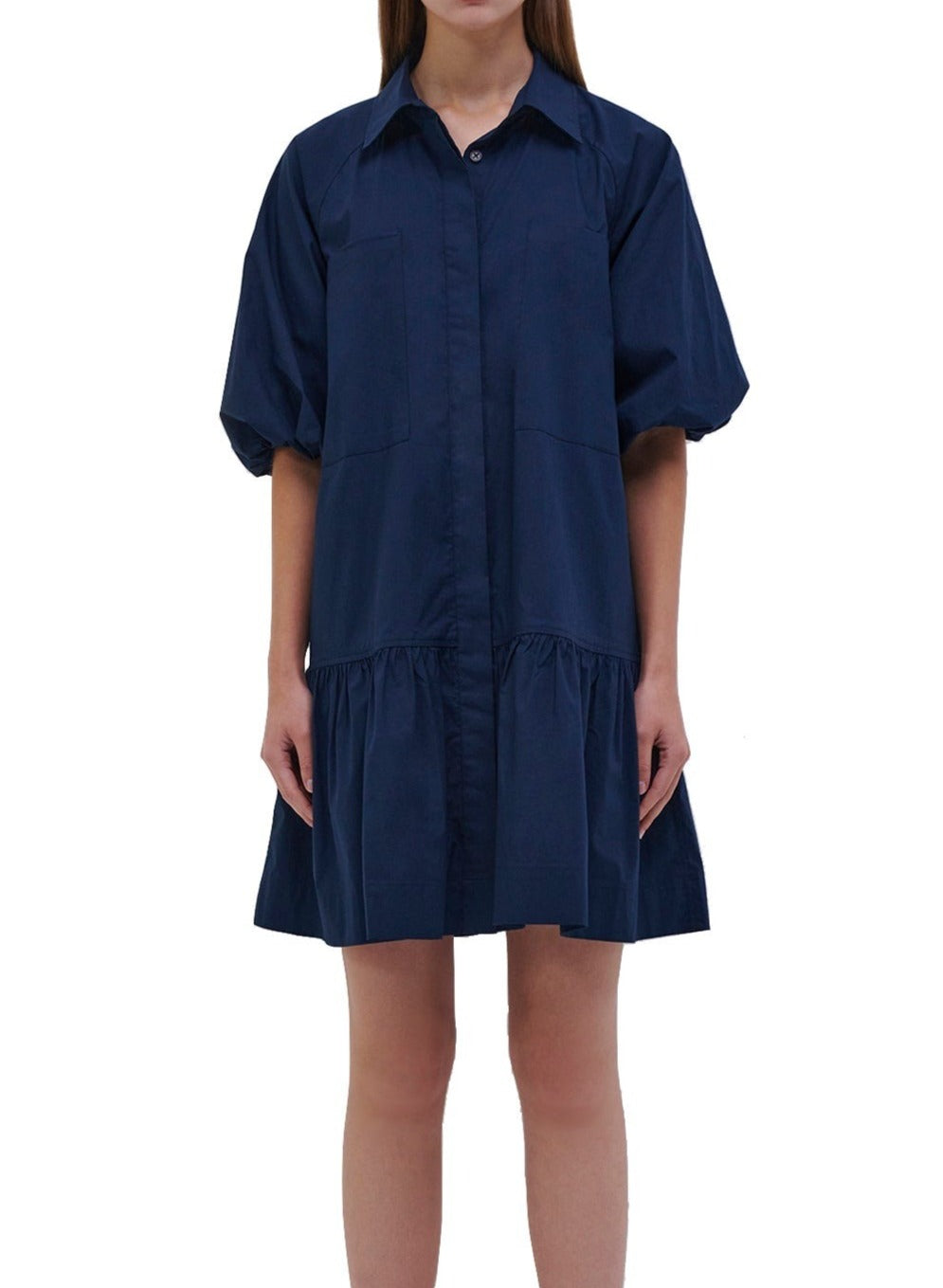 A woman wearing a navy Simkhai Crissy Shirt Dress.