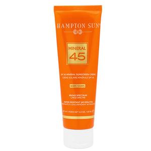 An orange tube of Hampton Sun SPF 45 Mineral Body Creme, 100 mL, with non-nano zinc oxide for broad spectrum, water-resistant (40 min) sun protection and anti-aging benefits.