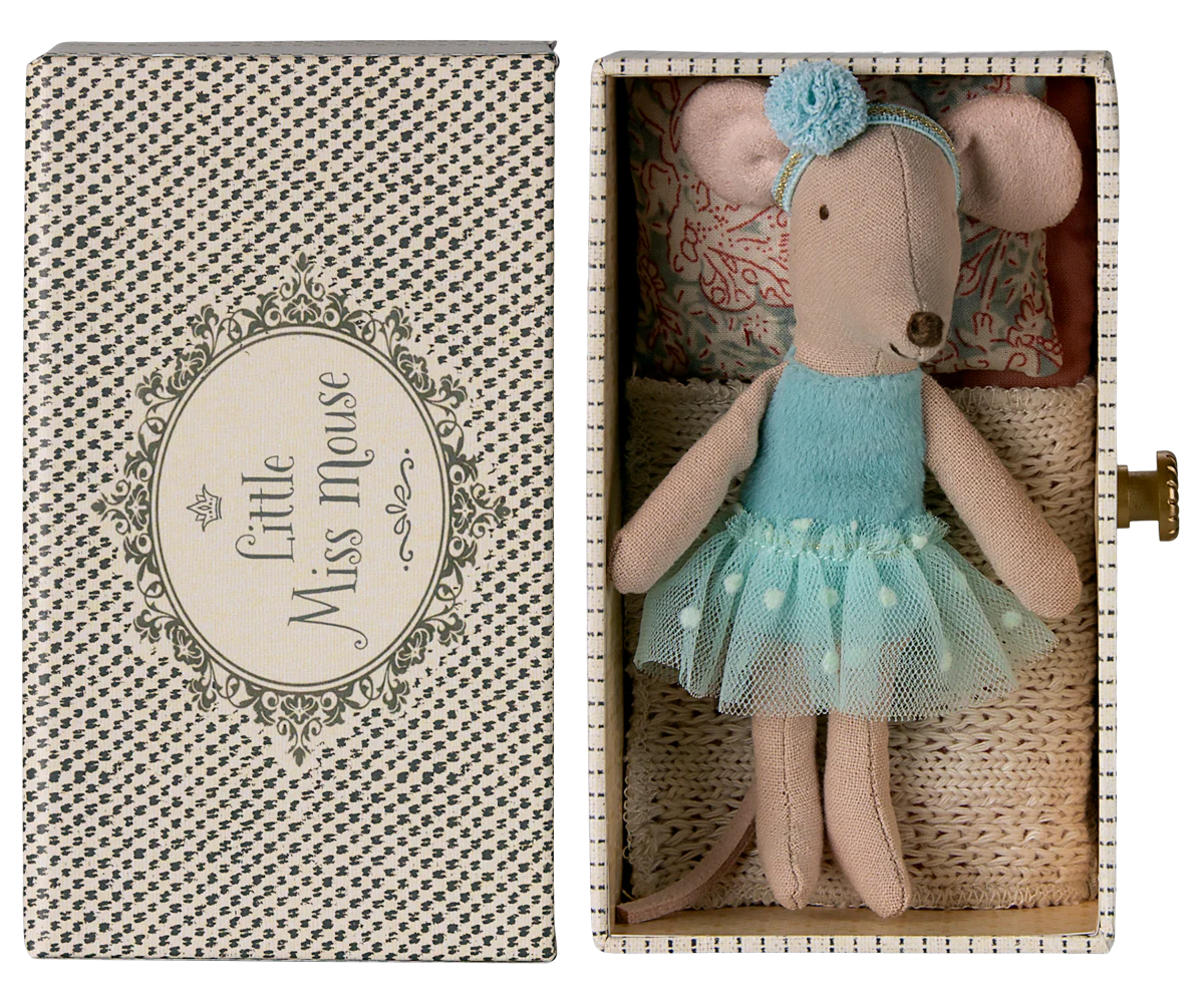 A small Maileg Dance Mouse in Daybed, Little Sister, wears a blue dress and headband and lies in a patterned box.