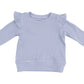 The Angel Dear Girls' Ruffle Shoulder Waffle Shirt + Ribbed Flare Pant in light purple is shown laid flat on a white background, featuring long sleeves and ruffled shoulders.