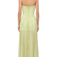 A woman is seen from the back against a white background wearing the Simkhai Sandrine Dress, a strapless maxi in pale yellow with a paneled bodice, highlighting its elegant and elongated silhouette.