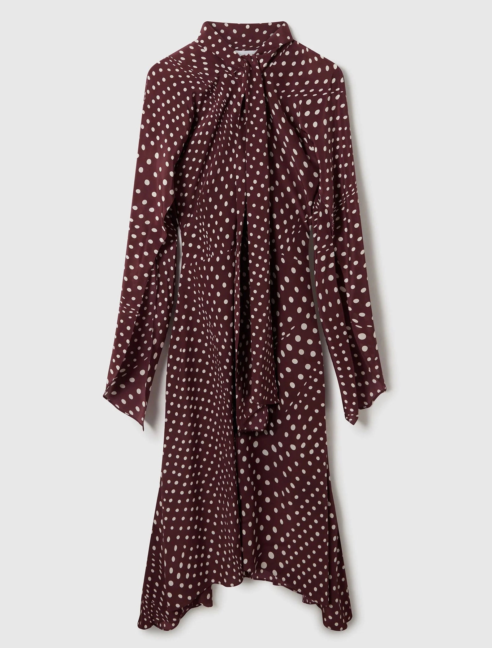 The Stella McCartney Tie-Neck Polka Dot Silk Dress, featuring long sleeves, a knee-length midi silhouette, and a flattering maroon polka dot design with flared cuffs and a chic tie-neck detail, is displayed against a light background.