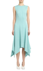 A person wearing the Stella McCartney Aquamarine Midi Dress with a handkerchief hem and white shoes, standing against a plain background.