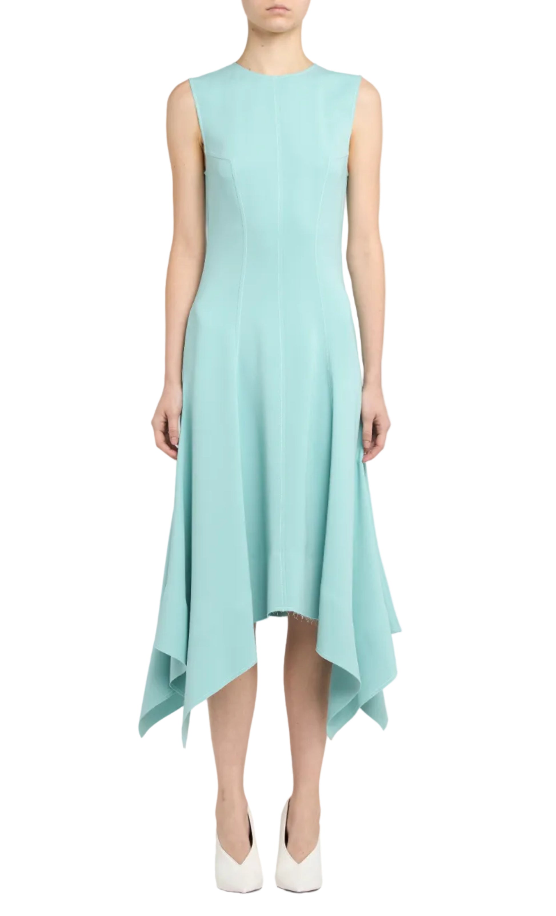 A person wearing the Stella McCartney Aquamarine Midi Dress with a handkerchief hem and white shoes, standing against a plain background.